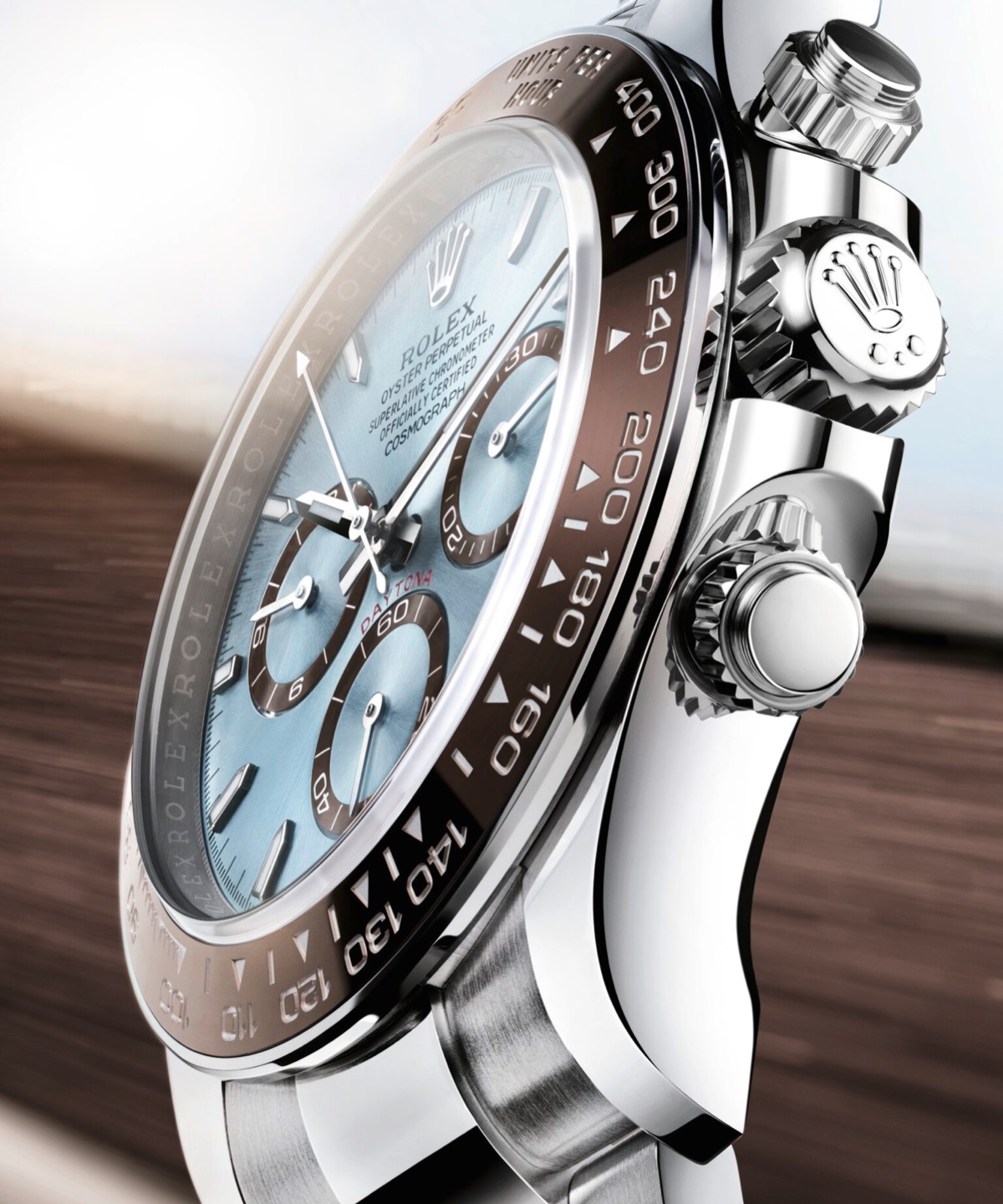 Side profile close-up of the Rolex Cosmograph Daytona in 950 platinum, highlighting the brown Cerachrom tachymetric bezel, ice blue dial, chronograph pushers and Rolex crown