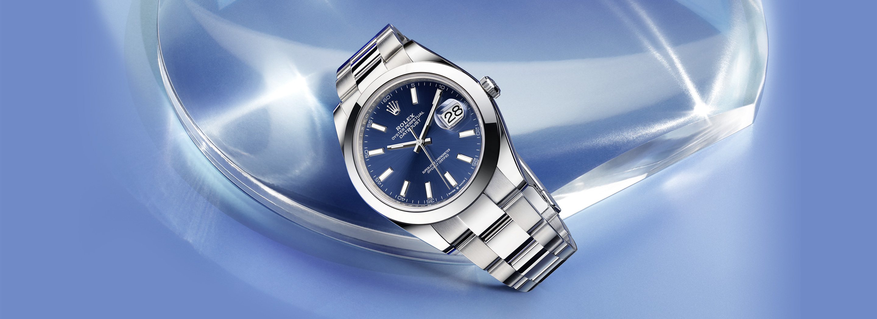 Rolex Datejust 41 in Oystersteel with blue sunray dial and smooth bezel on an Oyster bracelet, set against a blue crystal and light background