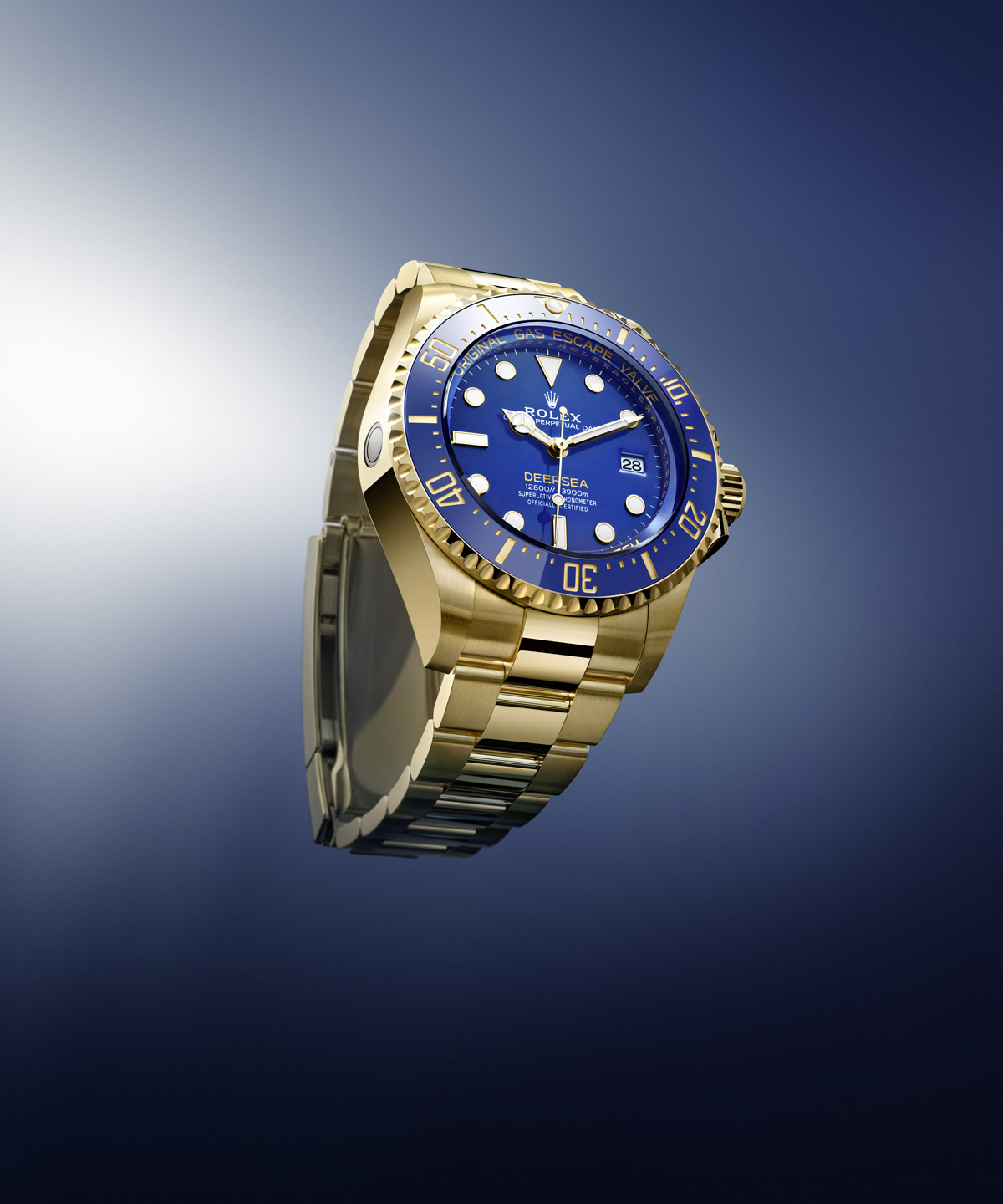 Rolex Deepsea in 18 kt yellow gold with blue dial and blue Cerachrom bezel on an Oyster bracelet, shown at an angle against a blue gradient background
