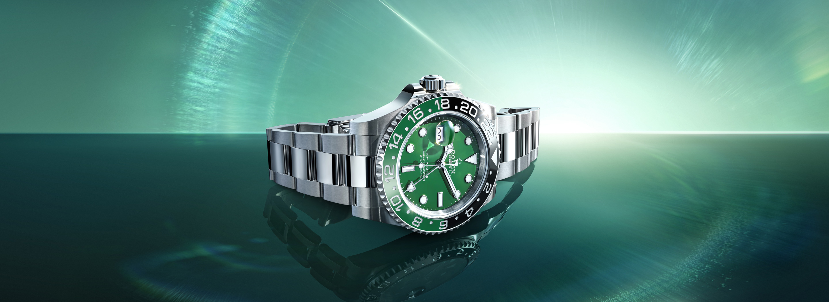 Rolex GMT-Master II in Oystersteel with green ceramic dial and green-black Cerachrom bezel on an Oyster bracelet, set against a sweeping green aurora light backdrop