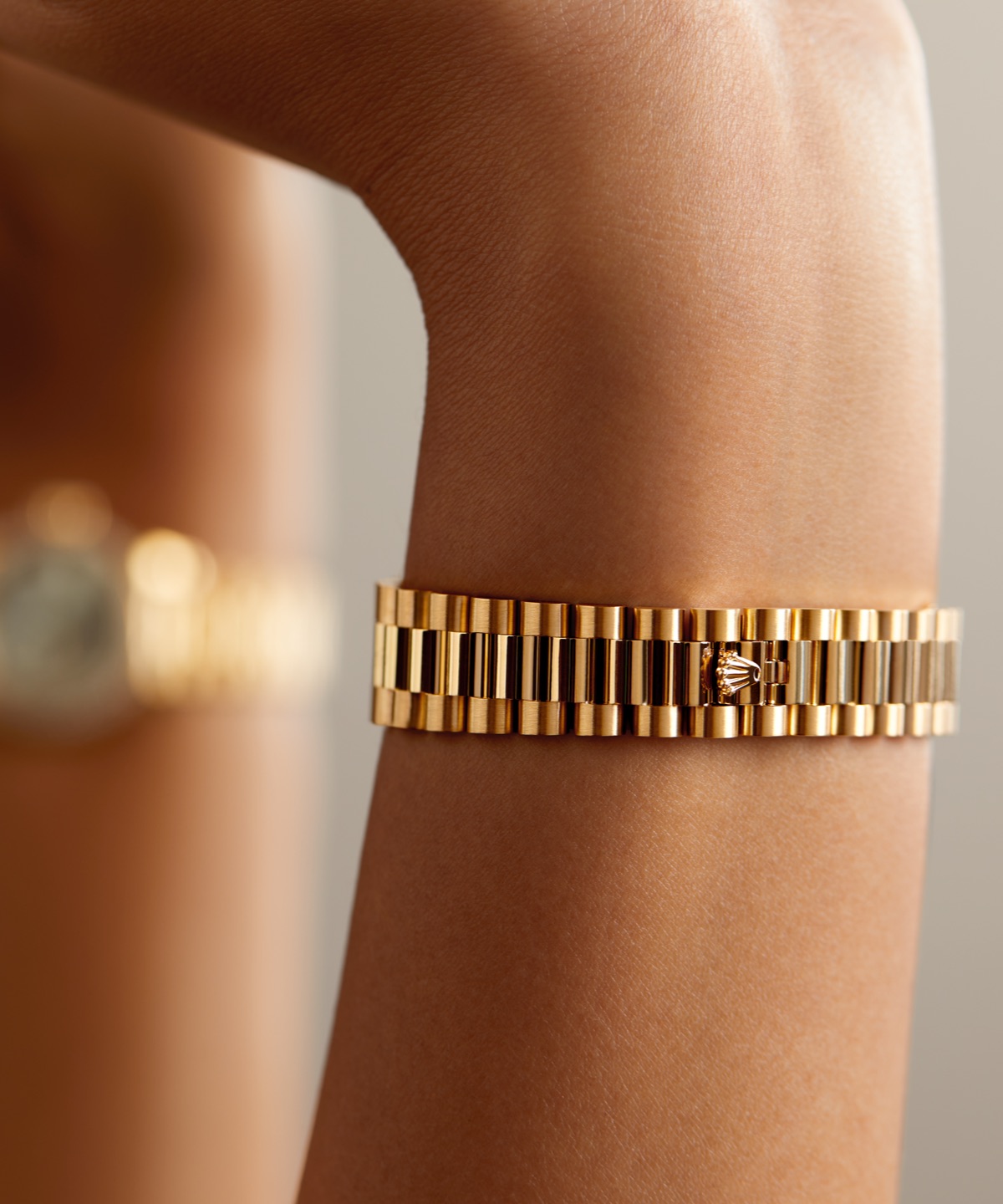 Close-up of the Rolex Lady-Datejust yellow gold President bracelet worn on a wrist, showing the three-piece links and Crownclasp detail