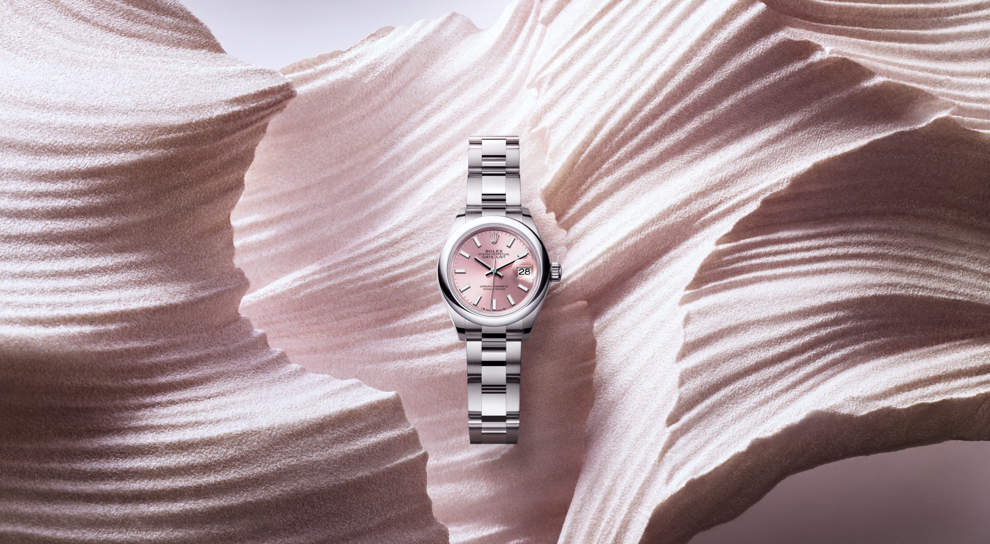 Rolex Lady-Datejust 28 in Everose gold with chocolate sunray dial and diamond hour markers on a President bracelet, set against a warm rose gold striped background