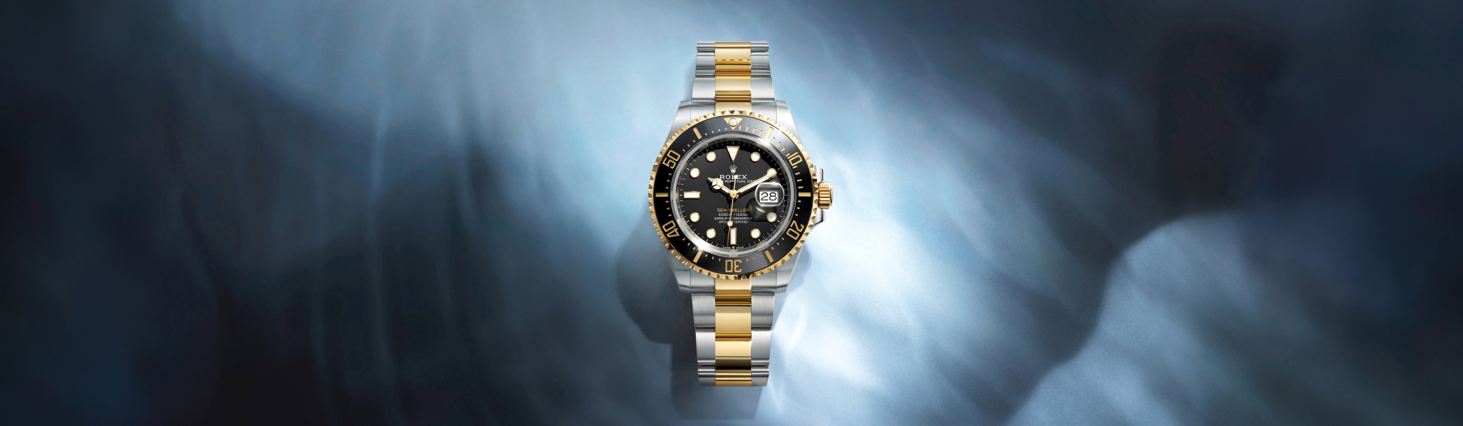 Rolex Sea-Dweller in Oystersteel and yellow gold Rolesor with black dial and black Cerachrom bezel on an Oyster bracelet, against a deep underwater background