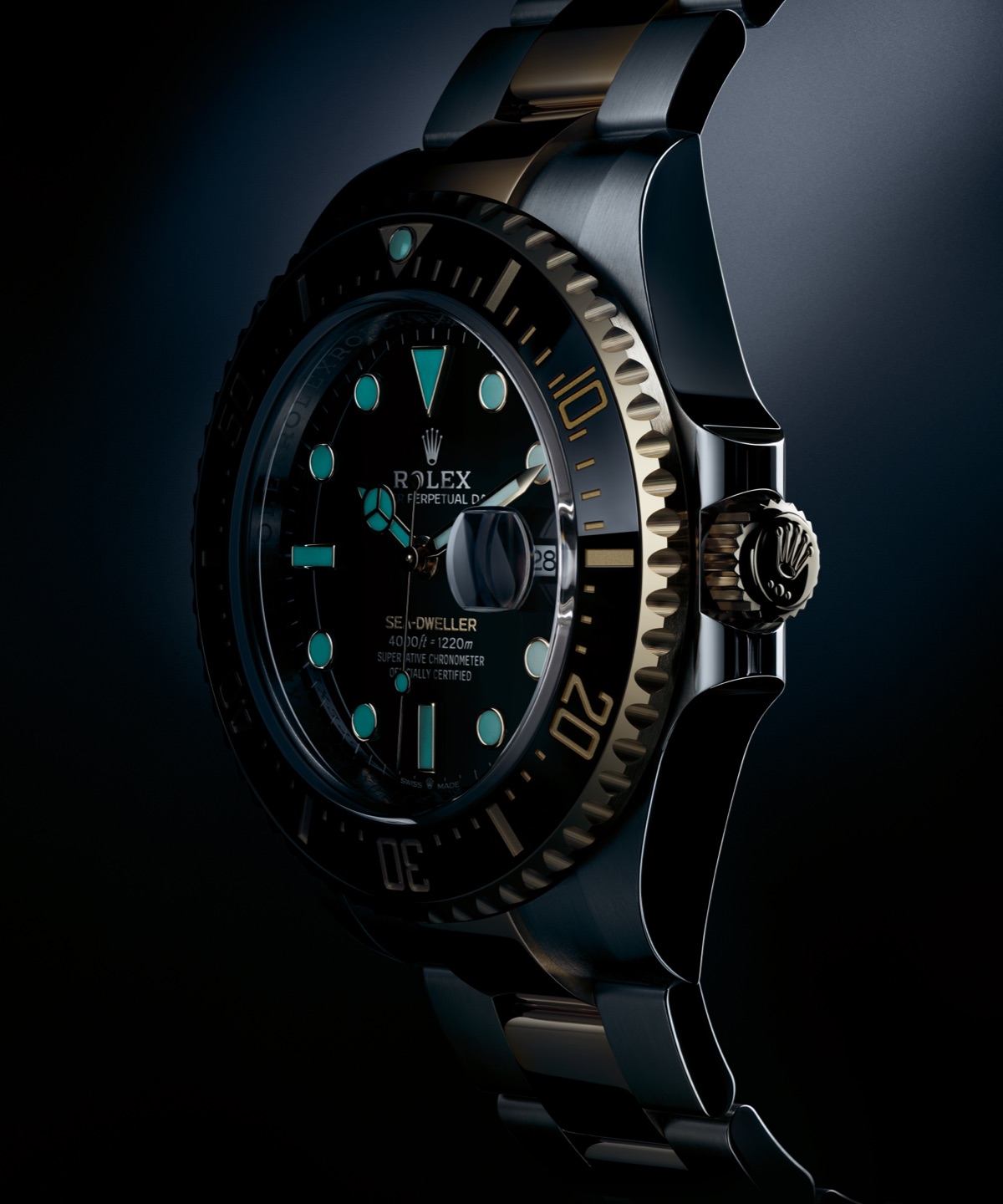 Rolex Sea-Dweller in Oystersteel and yellow gold Rolesor photographed in the dark, showing the Chromalight luminescent hour markers, hands and bezel triangle emitting an intense blue glow