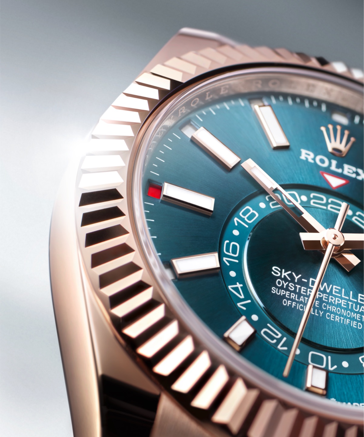 Close-up of the Rolex Sky-Dweller in Everose gold with blue sunray dial, showing the Saros annual calendar month indicators around the dial circumference and the 24-hour second time zone disc