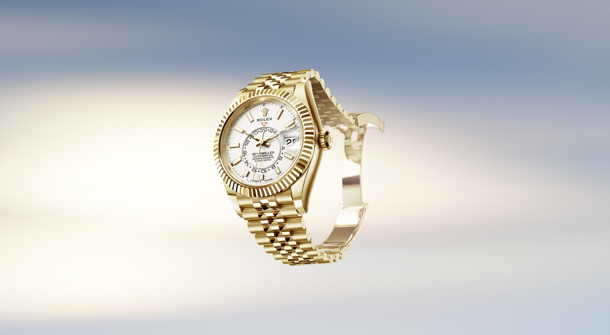 Rolex Sky-Dweller in yellow gold with black dial and fluted bezel on an Oyster bracelet, floating against a sky background